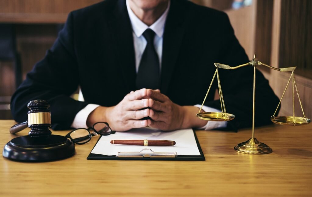 A professional lawyer sitting at a desk with a gavel, legal documents, and scales of justice, symbolizing the legal services provided by Siri Legal Services and Co. Advocates in Bangalore.